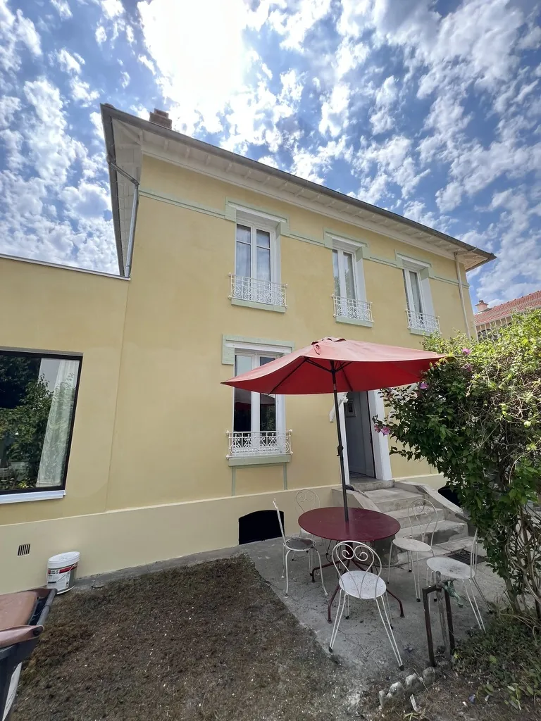 Façade sur jardin après le ravalement : teinte jaune paille, bandeaux et encadrements vert pâle