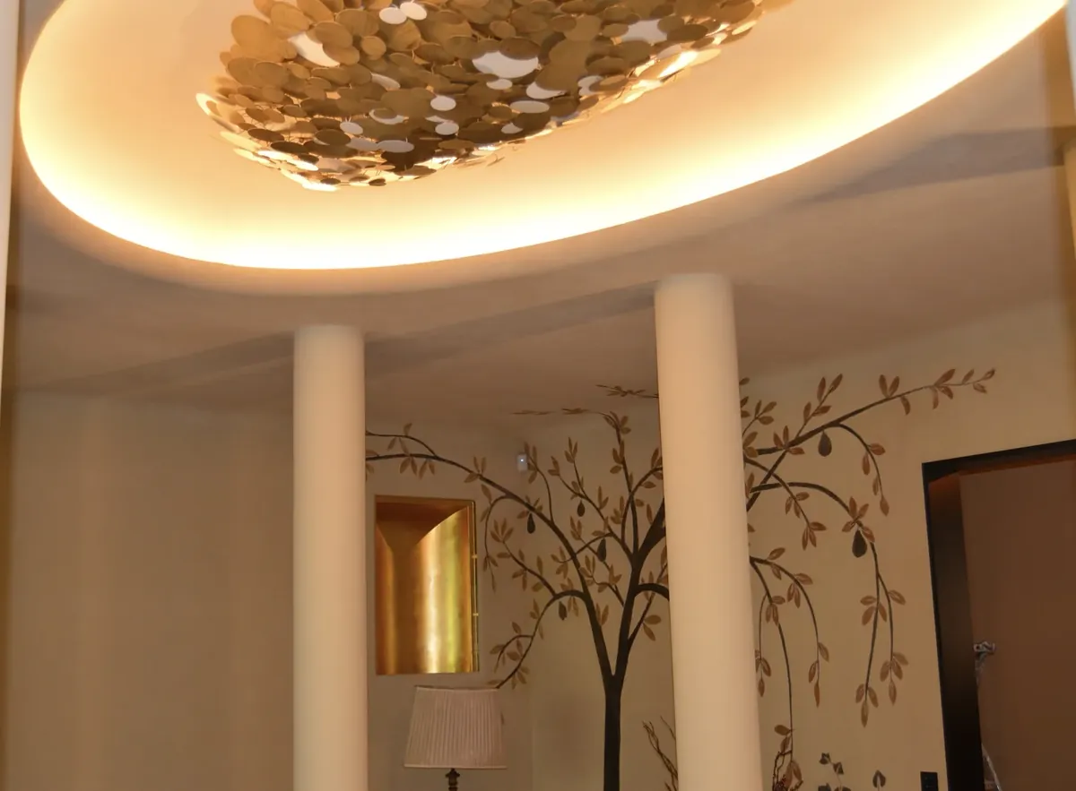 Hall à colonnes, plafond à gorge lumineuse et décor d’arbre peint