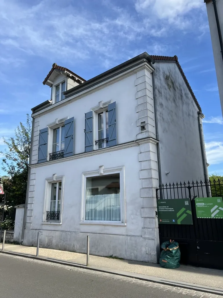 Town house with blue shutters before the facade work: greyed front, blackened gable