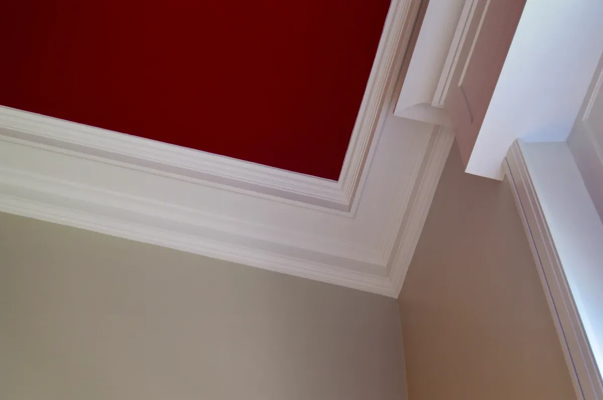Mise en peinture intérieure : plafond rouge profond, corniches rechampies en blanc