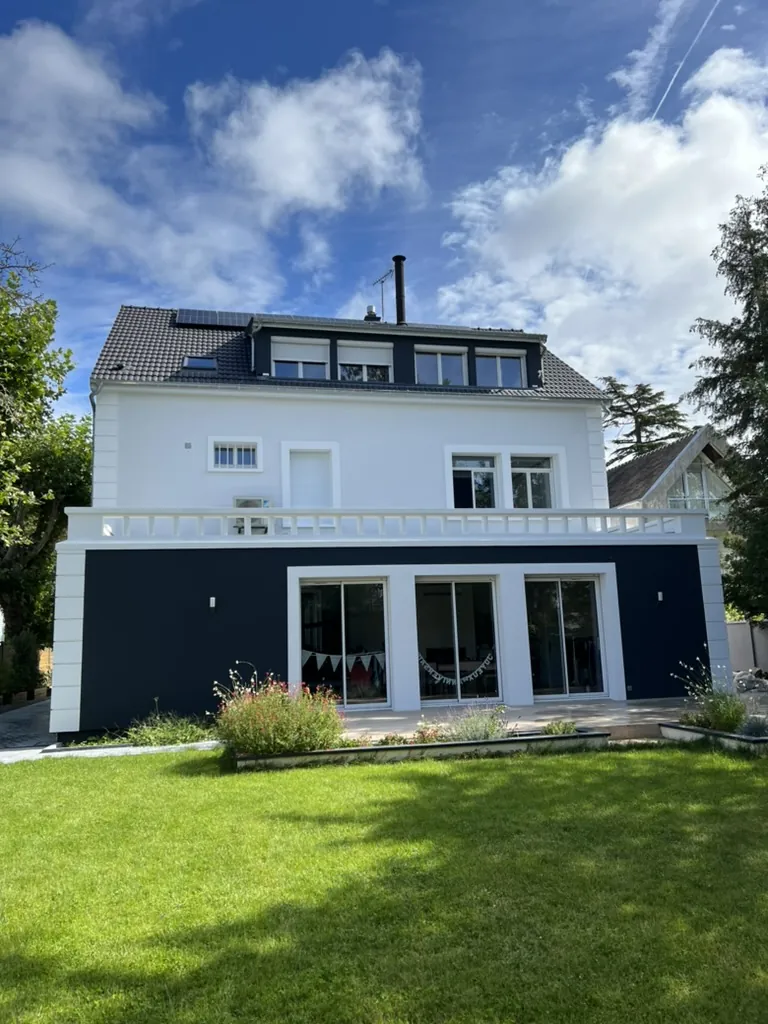 Grande maison à terrasse balustrée après le ravalement : façade blanche, rez-de-jardin bleu nuit