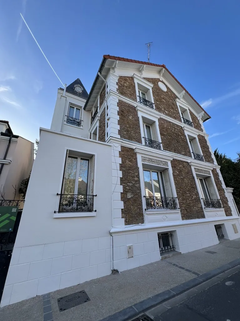 Villa en meulière à tourelle après le ravalement : chaînes d’angle, encadrements et aile enduite repris